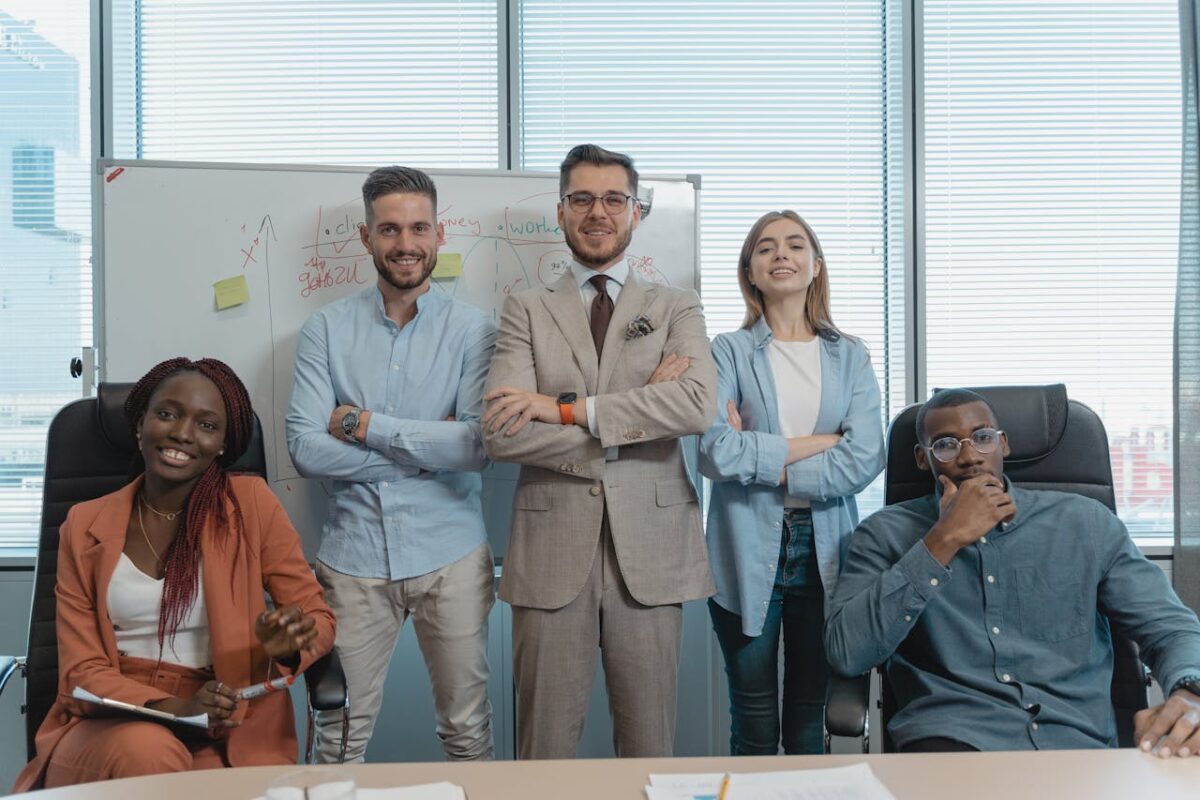 A multicultural group of business professionals confidently posing in a modern office.